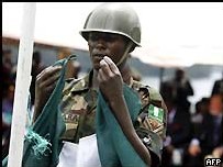 Un Soldat Nigerian descend le drapeau