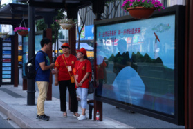Deux bénévoles renseignent un passager dans une station de bus à quelques jours du 11e Sommet du G20 à Hangzhou, capitale de la Province du Zhejiang (Est de la Chine), le 1er septembre 2016.