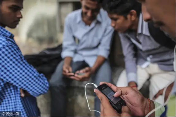 Un piéton (devant) utilise un smartphone Samsung à Mumbai (Bombay), en Inde. (PCP)