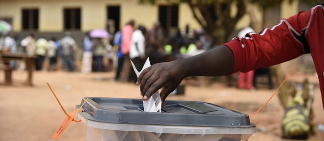 En Ouganda, dans le district de Wakiso, le 19 février 2016, un homme met son bulletin dans l'urne. © AFP / Isaac Kasamani