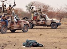 Des soldats tchadiens passent devant le corps d'un rebelle le 8 mai 2009 à Am Dam, à 130 km au sud d'Abeché