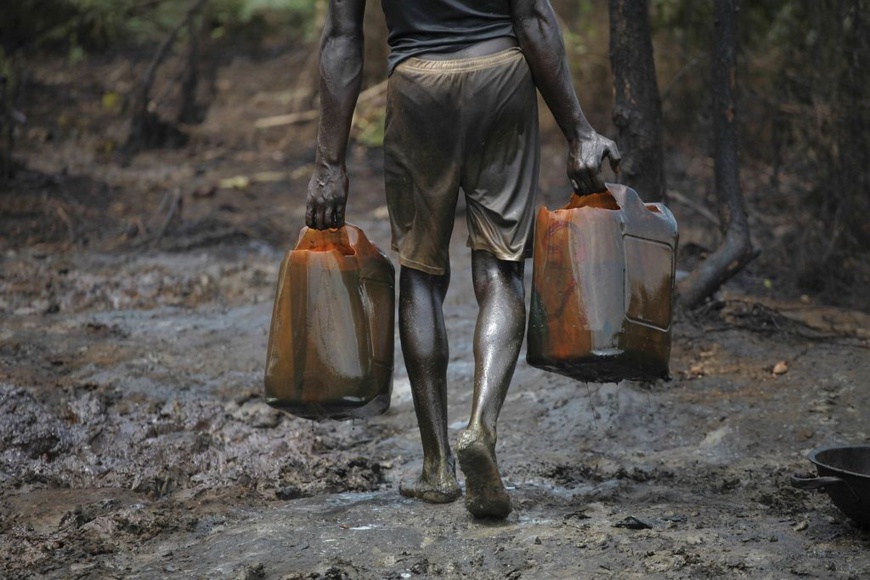 Dans une raffinerie illégale. Au Nigeria, des milliers de personnes participent à ce détournement de pétrole, connu localement sous le nom de "bunkering", qui consiste à trouer les pipelines pour voler du pétrole brut, qu'ils raffinent ou vendent directement. REUTERS/AKINTUNDE AKINLEYE Dans une raffinerie illégale. Au Nigeria, des milliers de personnes participent à ce détournement de pétrole, connu localement sous le nom de "bunkering", qui consiste à trouer les pipelines pour voler du pétrole brut, qu'ils raffinent ou vendent directement. REUTERS/AKINTUNDE AKINLEYE