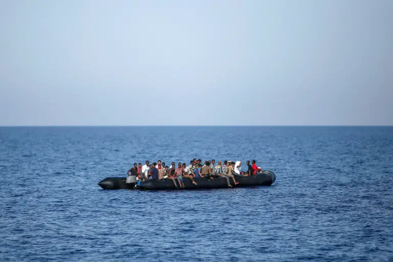 Des migrants attendent d'être secourus par les garde-côtes italiens près des côtes libyennes, le 6 août 2017 / © AFP / ANGELOS TZORTZINIS