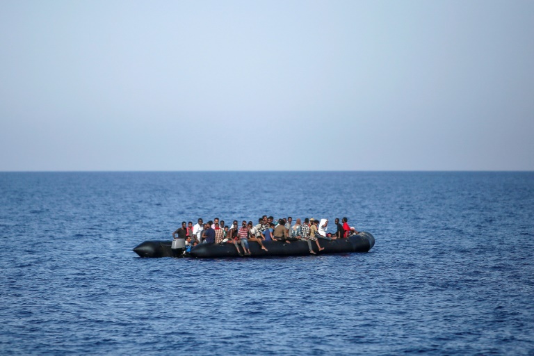 Des migrants attendent d'être secourus par les garde-côtes italiens près des côtes libyennes, le 6 août 2017 / © AFP / ANGELOS TZORTZINIS