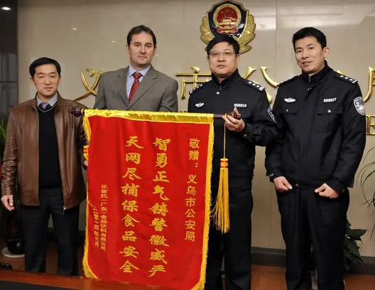 Danone, the French multinational food-product corporation based in Paris, presents a pennant to the police officers of the eastern Chinese city Yiwuin 2014, to express their gratitude to the police for uncovering a case of trademark infringement involving Danone’s beverage products. (Photo from Public Security Bureau of Yiwu, Zhejiang province )