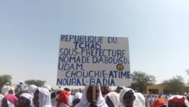Une femme brandit une pancarte lors de la journée internationale de la femme rurale à Abougoudam. Alwihda Info/D.H.