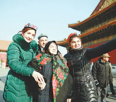 Great granddaughter of Kurban Tulum (fourth left), a Uygur patriot, accompanies a 106-year-old senior Uyghur (third left) to visit the Tian'anmen Rostrum in Beijing, January 19, 2016. The story of Kurban Tulum riding a donkey from Xinjiang to Beijing in the 1950s is widely known in Xinjiang. (Photo by People’s Daily)