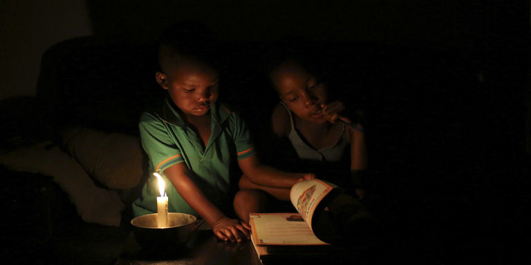 A Soweto, en Afrique du Sud, Sinovuyo Bhungane, 9 ans, fait ses devoirs à la bougie. CRÉDITS : REUTERS