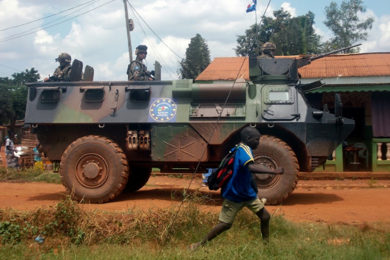 Un groupe de soldats français de la mission Sangaris passe près d'un enfant à Bangui, en Centrafrique, le 13 juillet 2014 / © AFP/Archives / PACOME PABANDJI