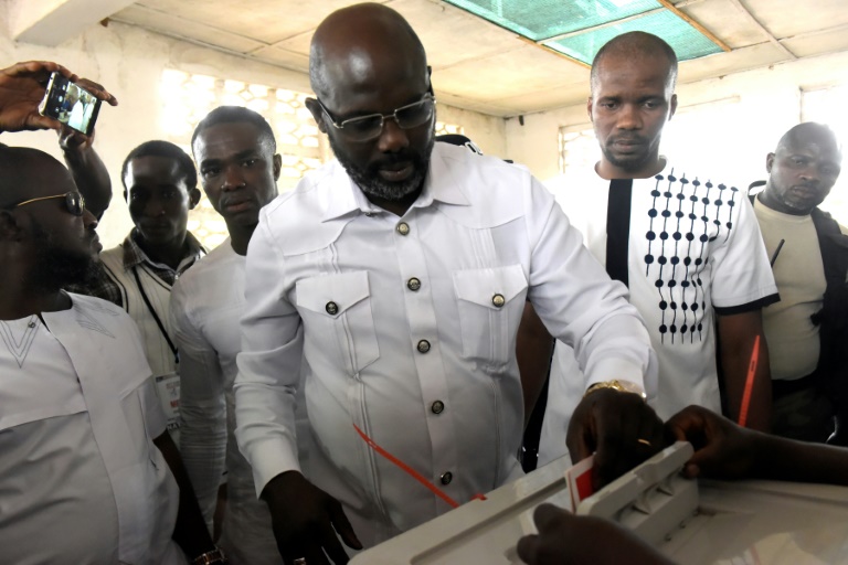 George Weah, candidat à la présidentielle, dépose son bulletin de vote, le 26 décembre 2017 à Monrovia / © AFP / SEYLLOU George Weah, candidat à la présidentielle, dépose son bulletin de vote, le 26 décembre 2017 à Monrovia / © AFP / SEYLLOU