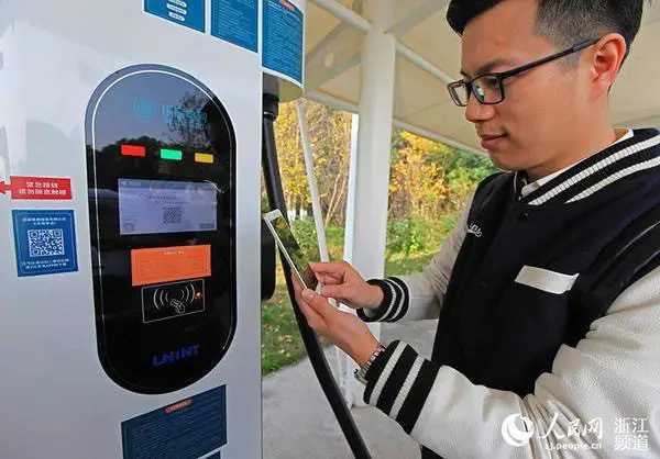 A motorist tests the quick-charging service for electric vehicles at an expressway service area in Ningbo, Zhejiang Province. The service has nearly achieved full coverage in the province. (Photo by People’s Daily Online)