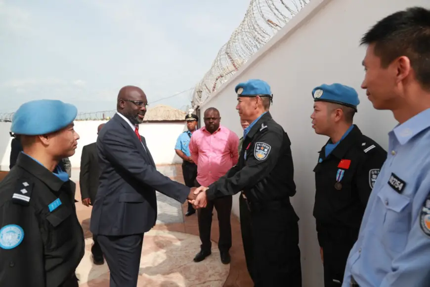 Liberian President George Weah (second from left) shakes hands with a member of the fifth Chinese peacekeeping police team in Monrovia, capital of Liberia. (Photo by Zhao Xiaoxin from People’s Daily)