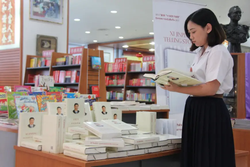 A Thai student leafs through Xi Jinping: The Governance of China, the collected speeches, talks, interviews, notes and letters of the Chinese leader. (Photo by Sun Guangyong from People’s Daily)