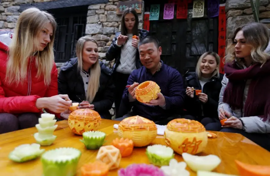 Foreign tourists learn to make turnip lanterns in Zhuquan Village, Yinan County, east China’s Shandong province. (Photo from CFP)
