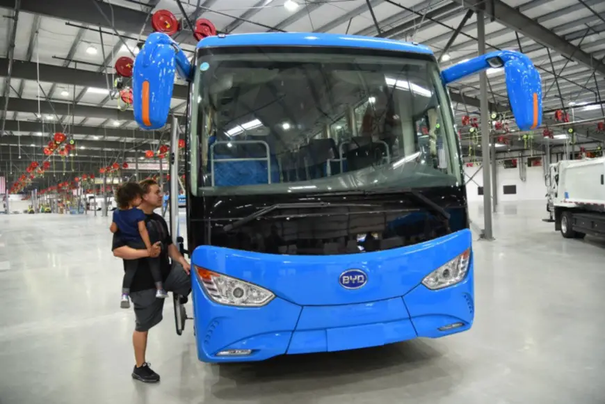 A US father taking his daughter to learn about an electric bus manufactured by BYD, October 6, 2017. On that day, the North American factory of BYD saw the completion ceremony of its third-phase extension project in Lancaster, Southern California, US. (Photo by Zhang Niansheng from People’s Daily)