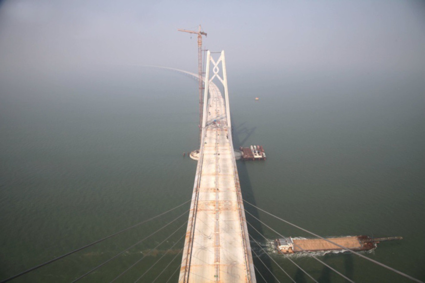 Decks of the Hong Kong-Zhuhai-Macao Bridge were linked together on September 27, 2016, indicating the main construction of the bridge entered into the final phase. Connecting Hong Kong with Macao and Zhuhai, the world’s largest sea-crossing span consists of a series of bridges and one undersea tunnel, as well as 3 artificial islands. (Photo by Ji Shunli from People’s Daily Online) Decks of the Hong Kong-Zhuhai-Macao Bridge were linked together on September 27, 2016, indicating the main construction of the bridge entered into the final phase. Connecting Hong Kong with Macao and Zhuhai, the world’s largest sea-crossing span consists of a series of bridges and one undersea tunnel, as well as 3 artificial islands. (Photo by Ji Shunli from People’s Daily Online)