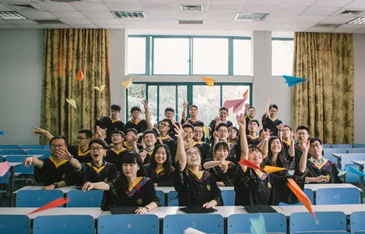 Graduates from Zhejiang University fly paper planes at a classroom, July, 2017. (Photo from People’s Daily Online)