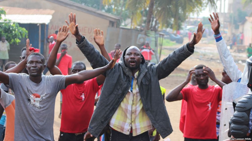 Mains levées, quelques manifestants essaient d’entamer une marche avant d’être dispersés à Lomé, Togo, 19 août 2017. (VOA/Kayi Lawson)