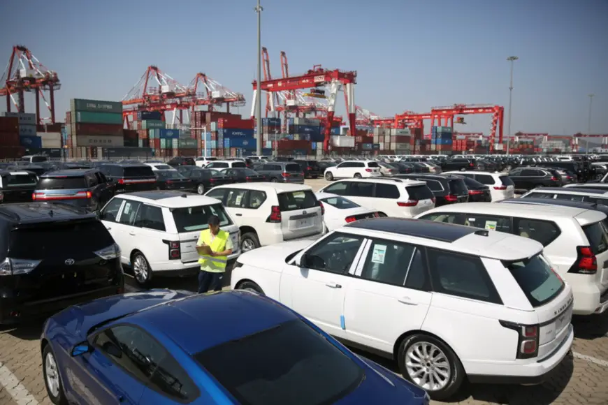 China will cut the import duty on passenger cars to 15 percent, almost 40% reduce, starting this July 1. Photo: staff at the Qingdao Qianwan Free Trade Port Zone check the imported vehicles. Source: People’s Daily