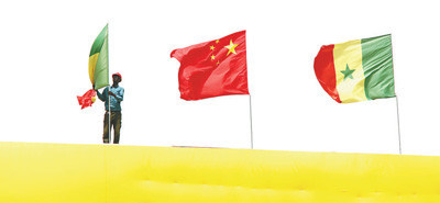 Chinese and Senegalese national flags fly on the National Wrestling Arena, built with Chinese assistance, to greet Chinese President Xi Jinping’s arrival. (By Li Zhiwei from People’s Daily)