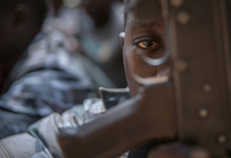 Un enfant-soldat regarde à travers la crosse d'un fusil au cours d'une cérémonie de libération à Yambio, au Soudan du Sud, le 7 février 2018 / © AFP/Archives / Stefanie Glinski