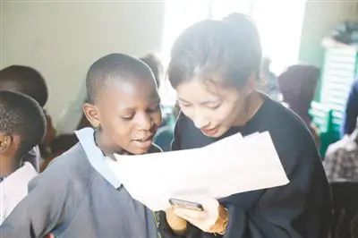 A Chinese volunteer is tutoring a slum child in Kenya. (Photo by Lv Qiang from People’s Daily)