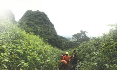 Members of the Green Boat Emergency Rescue search for trapped Thai people at the cave entrance. (File photo)