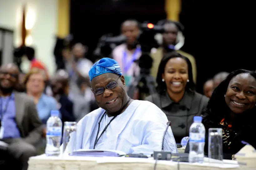 Former President of Nigeria, Olusegun Obasanjo and his daughter, Enitan Obasanjo share a light moment during the session. Behind them is C.E.O of Rwanda Development Bank, Clare Akamanzi.