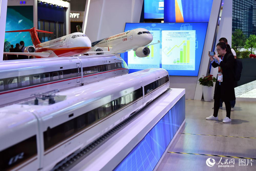 A journalist takes pictures at the China Pavilion during the first CIIE on Nov. 5. Photo by Weng Qiyu from People’s Daily Online