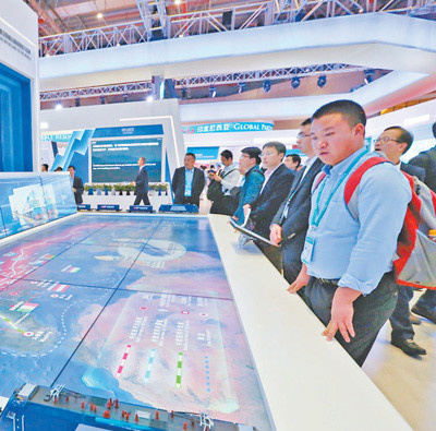 Visitors are observing at the booth of China-Europe freight trains in the China pavilion. (Photo by Li Yi from People’s Daily)