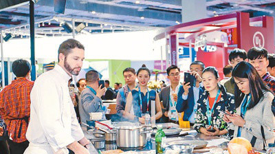 At the CIIE Consumer Electronics & Appliances exhibition area, a staff of an American company introduces smart cooking utensils and related products that can meet diverse user demands. (Photo by Ma Sichao from People’s Daily)