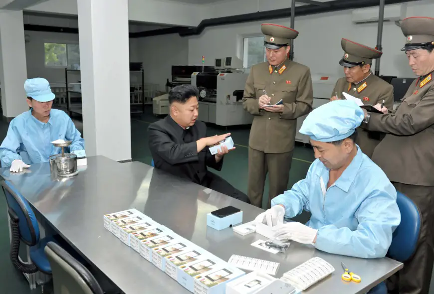 Kim Jong-Un observe le nouveau smartphone « made in Coree du Nord » dans l'usine de Pyongyang