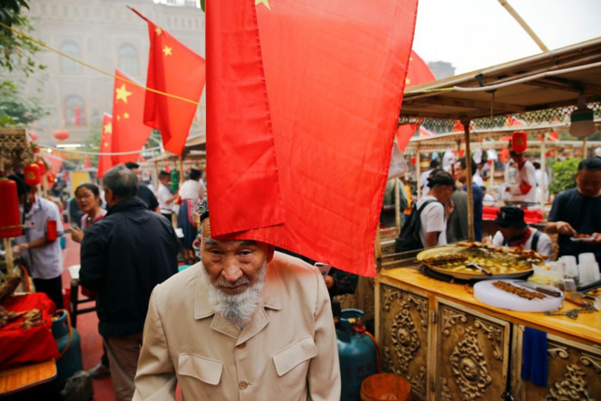 Des drapeaux chinois flottent au vent sur le marché dans la vieille ville de Kachgar, dans la province du Xinjiang. Photo du 6 septembre 2018. (© Thomas Peter/Reuters)