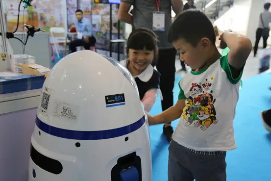 Photo shows teacher robot Xiaopang with children. ( Photo: Courtesy of Evolver company)