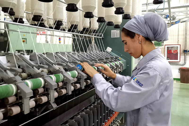 A Tajik worker is spinning at a workshop of a textile agricultural industry park built by China’s Zhongtai Group. Photo by Chen Shangwen, People’s Daily