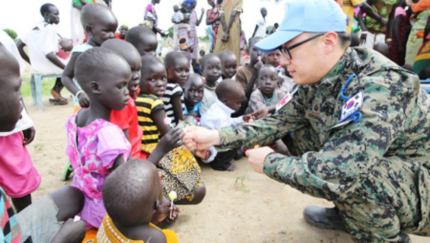 Un médecin militaire sud-coréen donne des friandises à un enfant sud-soudanais. © Etat-major des armées sud-coréen