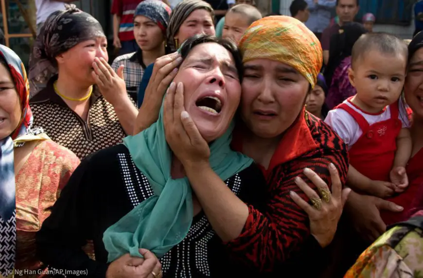 Des femmes ouïgoures affligées suite à une série d’arrestations à Xinjiang, en Chine. (© Ng Han Guan/AP Images)