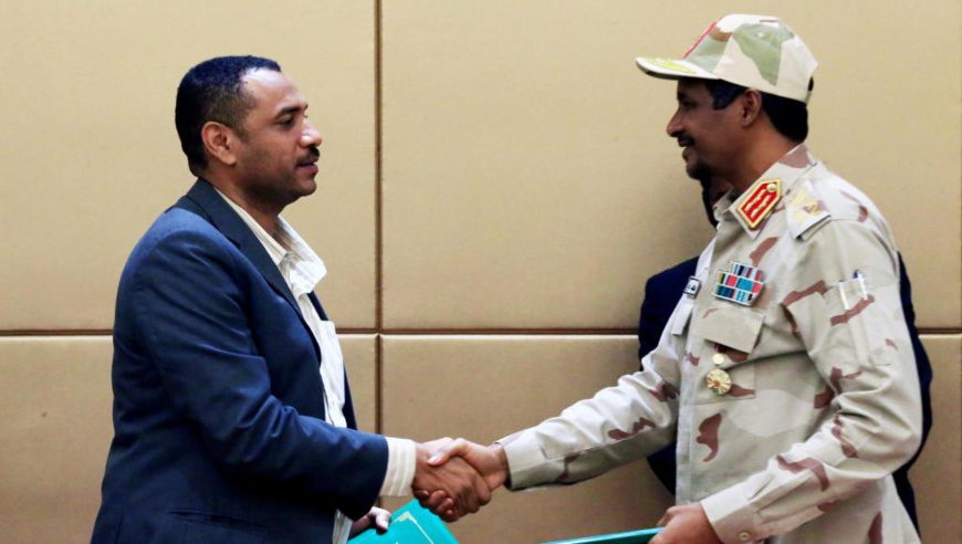 Le leader de la coalition d'opposition Ahmad al-Rabiah et le chef du conseil militaire de transition Mohamed Hamdan Dagalo, lors de la cérémonie de signature à Khartoum, le 4 août. © REUTERS/Mohamed Nureldin Abdallah