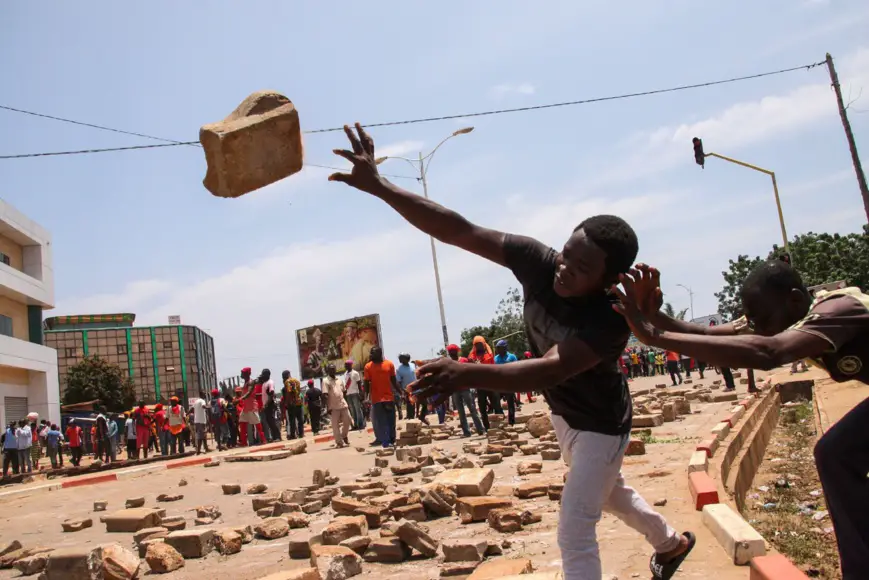 Un jeune manifestant lance un pavé au Togo. © DR