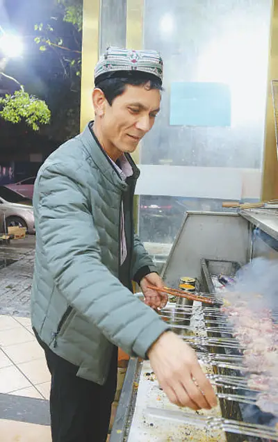 Abdullah Urasimu roasts kebabs skillfully in his restaurant. The restaurant, which is about 300 meters from Bayi Square in Nanchang, east China’s Jiangxi Province, sees a continuous stream of customers every day. (Photo by Dai Linfeng/People’s Daily)