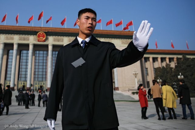 Un soldat en tenue de ville empêche des journalistes de s’approcher trop près du Grand Hall du peuple à Beijing, en mars. (© Andy Wong/AP Images)
