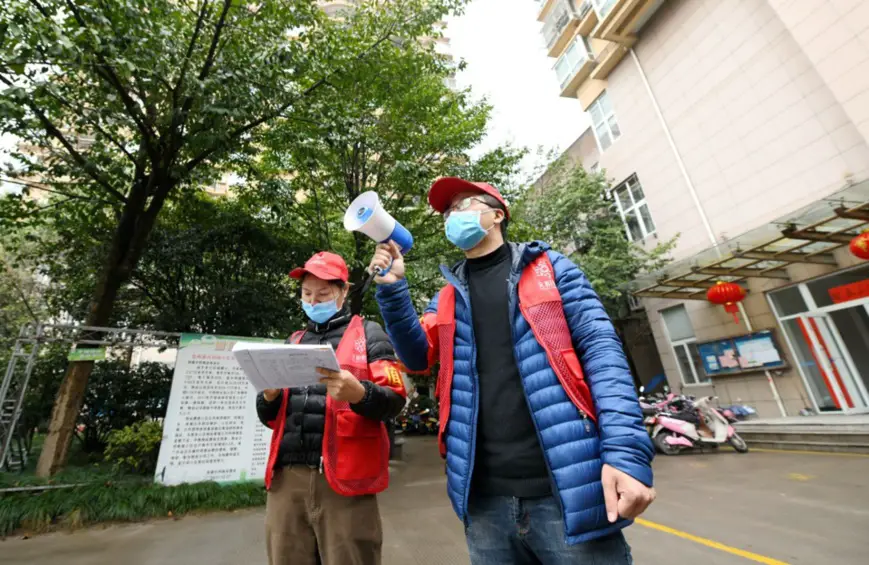 On February 4, 2020, in a community in Nanfeng Street, Xianju County, Zhejiang Province, volunteers are using small speakers to publicize epidemic prevention knowledge. (Photo by Wang Huabin from People’s Daily Online)