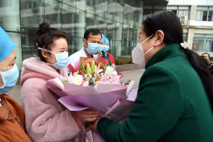 A 25-year-old woman surnamed Li, accompanied by medics, walks out of the isolation ward of People’s Hospital of Bozhou, east China’s Anhui Province at 9:00 am, Jan. 29, 2020. She is the first cured patient of the novel coronavirus in Bozhou and among the first batch in Anhui. (Photo by Zhang Yanlin from People’s Daily Online)