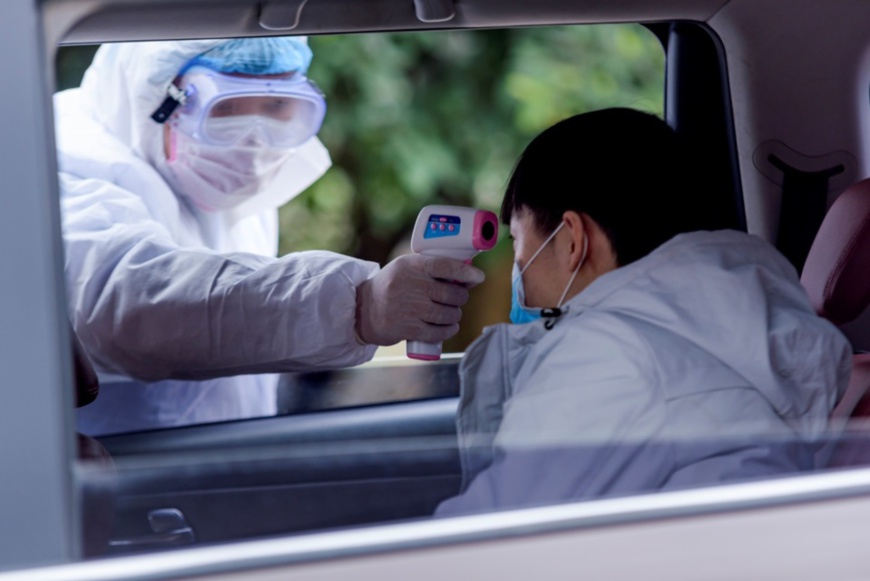 On Feb. 1, a staff member at a checkpoint in Leshan, southwest China’s Sichuan province takes temperature of a citizen. (By Zeng Ling, People’s Daily Online)