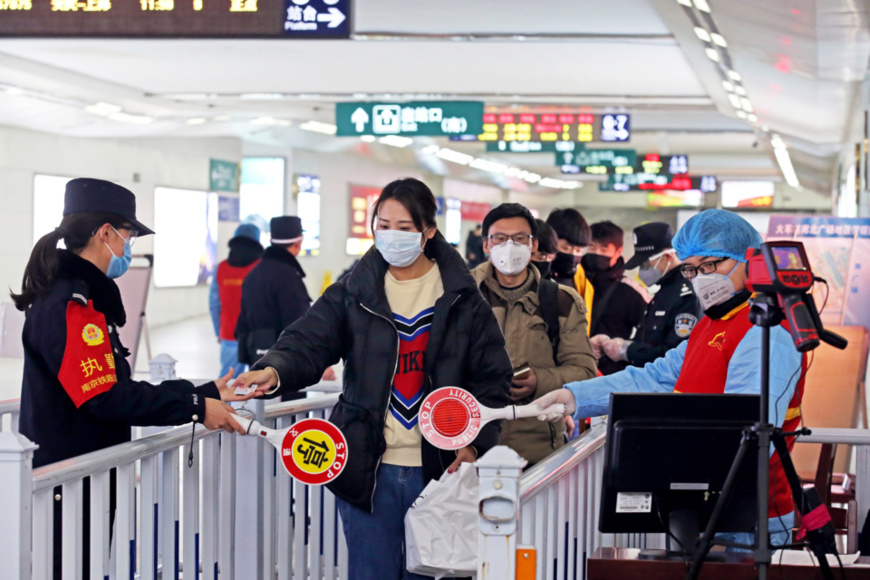 Photo taken on Feb. 2, 2020 shows policemen, medical staff and volunteers take passengers' body temperature and check identity information to prevent and control epidemic at the exit of a railway station in Changzhou, east China’s Jiangsu province, where the passenger traffic increased gradually. Chen Wei/People’s Daily Online