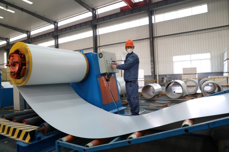 A worker produces sandwich panels at a workshop of Wiskind Group, a company engaged in steel building and trading in Binzhou, east China’s Shandong province, Feb. 9. Sandwich panel is a special construction material used for building structures that have extremely high requirements on indoor environment. (Photo by Chen Bin, People’s Daily Online)