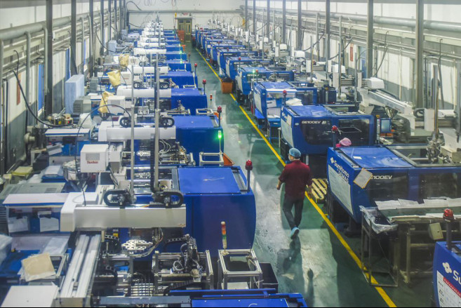 Workers check machines at a workshop of Ningbo Jieli Cosmetical Package company in Yuyao, east China’s Zhejiang Province, Feb.25, 2020. Enterprises in the city have smoothly restarted production, making the most of intelligent equipment such as automated production lines and intelligent robots. Photo by Zhang Hui, People’s Daily Online