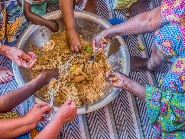 Une famille mange mange ensemble de façon traditionnelle. Illustration. © Istock/Getty Images