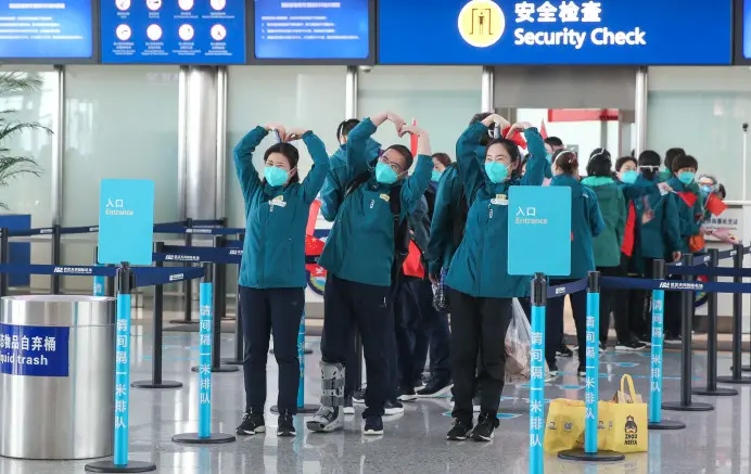 Medics from the Peking Union Medical College Hospital bid a farewell to Wuhan making a heart shape over their heads at Wuhan Tianhe International Airport, April 15, 2020. Wu Yu/People’s Daily Online