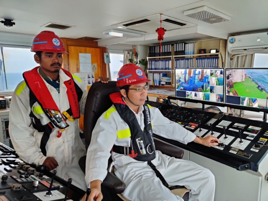 Captain of cutter suction dredger Lilong teaches a foreign assistant driver how to operate the machine. Photo by Qu Xiangyu, People’s Daily